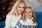 Close-up portrait of charming blonde mother and daughter sitting