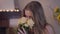 Close-up portrait of charming Caucasian brunette woman smelling bouquet of yellow roses and smiling at camera. Happy