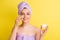 Close-up portrait of charming cheerful girl using cream pure skin vitality  over vibrant yellow color background