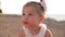 Close-up portrait of charming pretty baby girl enjoying taste of healthful watermelon on family picnic outdoors in