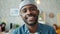 Close-up portrait of cheerful African American guy smiling indoors in office