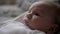 Close Up Portrait Of Cheerful Newborn Baby Cute Pouted His Lips Lying In Bed