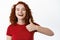 Close up portrait of cheerful and positive ginger girl with curly long hair, showing thumb up in approval and say yes