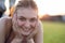 Close up portrait of cheerful smiling young girl with freckles on her face outdoors in sunny summer day. Human expressions and