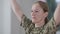 Close-up portrait of concentrated motivated military woman working out indoors. Middle aged Caucasian female soldier