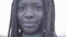 Close up portrait of confident african american young black smiling woman on the background of sky and street.