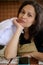 Close-up portrait of a confident beautiful woman, chef confectioner in beige apron, holding white cap, looking at camera