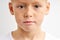 close up portrait of confident child with freckles and big green eyes looking in camera with serious expression