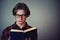 Close up portrait contented student boy, wearing eyeglasses, enjoy reading his favorite book isolated on grey wall background with