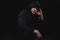 Close up portrait of a courageous man in a deep dark hood on a black background. The concept of secrecy of secrets and