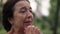 Close-up portrait crying frustrated senior Caucasian woman standing in park outdoors. Stressed depressed female retiree
