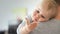 Close-up portrait of cute adorable blond caucasian toddler boy on fathers shoulder indoors. Sweet little child smiling