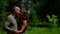Close-up portrait of a cute middle-aged couple in love, they are outdoors in a Park against a green background, gently