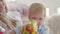 Close-up portrait of cute toddler in party hat celebrating holiday with family. Blond Caucasian little boy having first