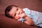 Close up portrait of a cute two weeks old newborn baby girl lying down