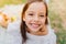 Close-up portrait of dark-eyed girl with cheerful smile posing with pleasure outdoor. Pretty little lady with brown eyes