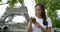 Close-up portrait of a dark-haired happy middle-aged woman against the background of rustling leaves and the Eiffel