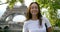 Close-up portrait of a dark-haired happy middle-aged woman against the background of rustling leaves and the Eiffel