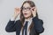 Close up portrait of a dazzling and astounded businesswoman, who is touching the black rim of glasses with both hands