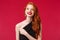 Close-up portrait of delighted pretty romantic redhead woman in red lipstick, black dress, contemplate something