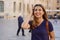 Close up portrait of delightful cheerful latin woman with toothy smile having a walk in a foreign city