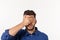 Close up portrait of disappointed stressed bearded young man in shirt closing eyes over white background.