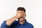 Close up portrait of disappointed stressed bearded young man in shirt closing eyes over white background.