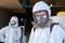 Close-up portrait of disinfectant male in medical gear and mask