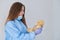 A close-up portrait of a doctor wearing an operating theatre outfit and brazing a teddy bear - isolated on a blue background.