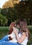 Close-up portrait of dog owner kissing small Cavalier king charles spaniel in park in summer. Young blond woman, having fun with