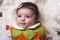 Close-up portrait of a dreamy baby girl with colorful sweater on