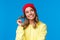 Close-up portrait dreamy silly cute european female in red hipster beanie, yellow hoodie, rolling curl on hair and