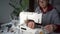 Close-up portrait of a dressmaker finished sewing and is cutting the threads. Pensioner sews home textiles