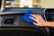 Close-up portrait of a driver woman cleaning her car with microfiber towel