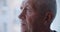 A close-up portrait of an elderly man in his 60s, who is looking thickly out the window Thoughts about old age