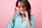 Close-up portrait of elegant hispanic female model wears colorful sunglasses and cotton shirt. Inspired latin woman in