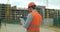 Close-up portrait of engineer with gadget on background of building under construction. Modern construction engineer or