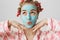 Close-up portrait of european girly girl with cute expression, wearing pyjamas and hair-curlers, standing with facial