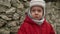 close-up Portrait of European little preschool boy in gray knitted hat red jacket sad, offend look at camera