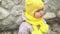 close-up Portrait of European little toddler dirty poor child grl in yellow knitted hat gray jacket smiling look at