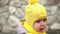 close-up Portrait of European little toddler dirty poor child grl in yellow knitted hat gray jacket smiling look at