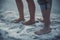 Close up portrait of feet, legs of couple standing near to the salt lake in salt