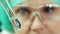 Close-up portrait - a female lab technician looks at a test tube with water. Water quality control concept