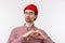 Close-up portrait funny caucasian male with geeky look, wear glasses and red beanie, pouting for kiss, showing heart