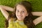 Close-up portrait of funny smiling little girl lying on green carpet