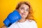 Close up portrait of funny woman with boxing gloves with punching face isolated on yellow background Woman in boxing