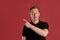 Close-up portrait of a ginger guy in black t-shirt posing on pink background. Sincere emotions.