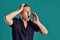 Close-up portrait of a ginger guy in navy t-shirt posing on blue background. Sincere emotions.