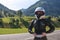 Close up portrait of a girl in full body protection, turtle armor, knee pads and helmet, on a background of green mountains,