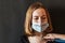 A close-up portrait of a girl in an icy mask on her face with suspected coronavirus, which the doctor listens with a stethoscope.